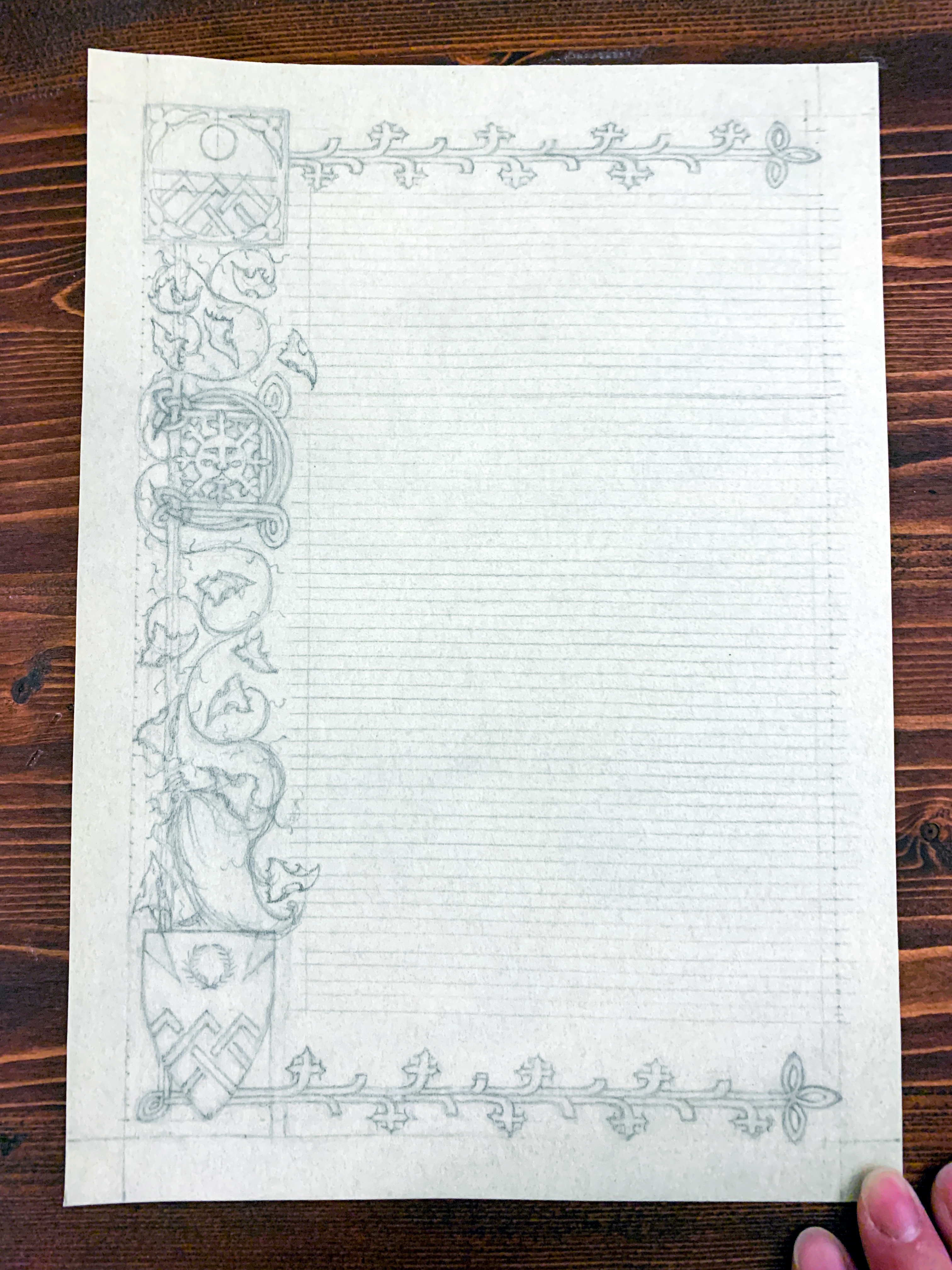 A medieval scroll award in progress: the pencil stage, all artwork is penciled in the left margin, top and bottom, with additional coiling vines and leaves